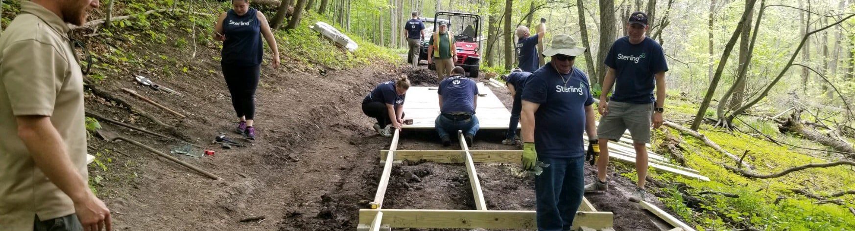 Employees at Germantown volunteering within their community, building a bridge at Pike Lake